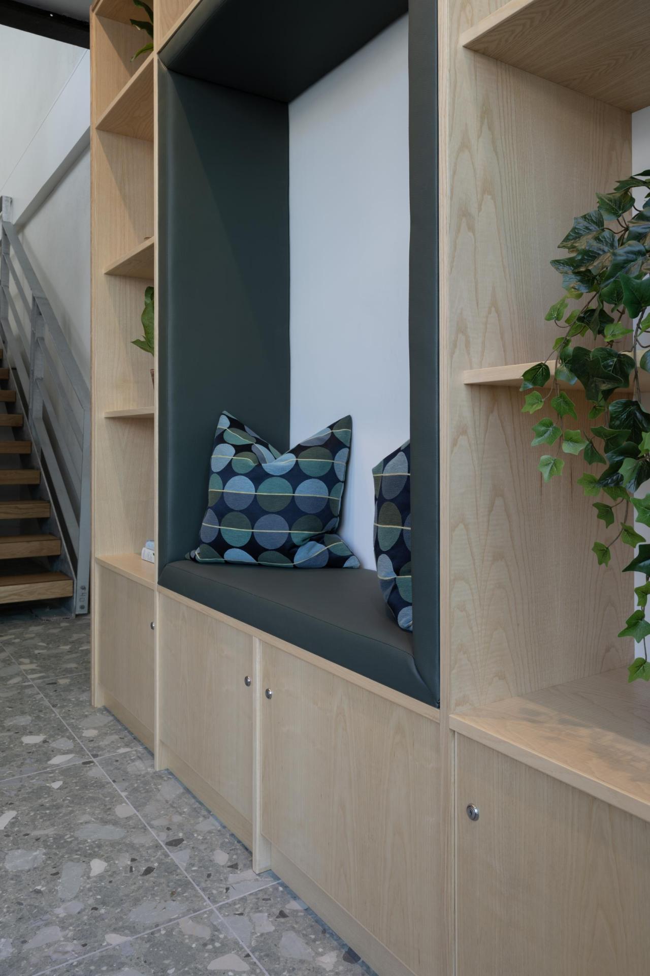 Detail view of seating and storage nook made from ash with green leather